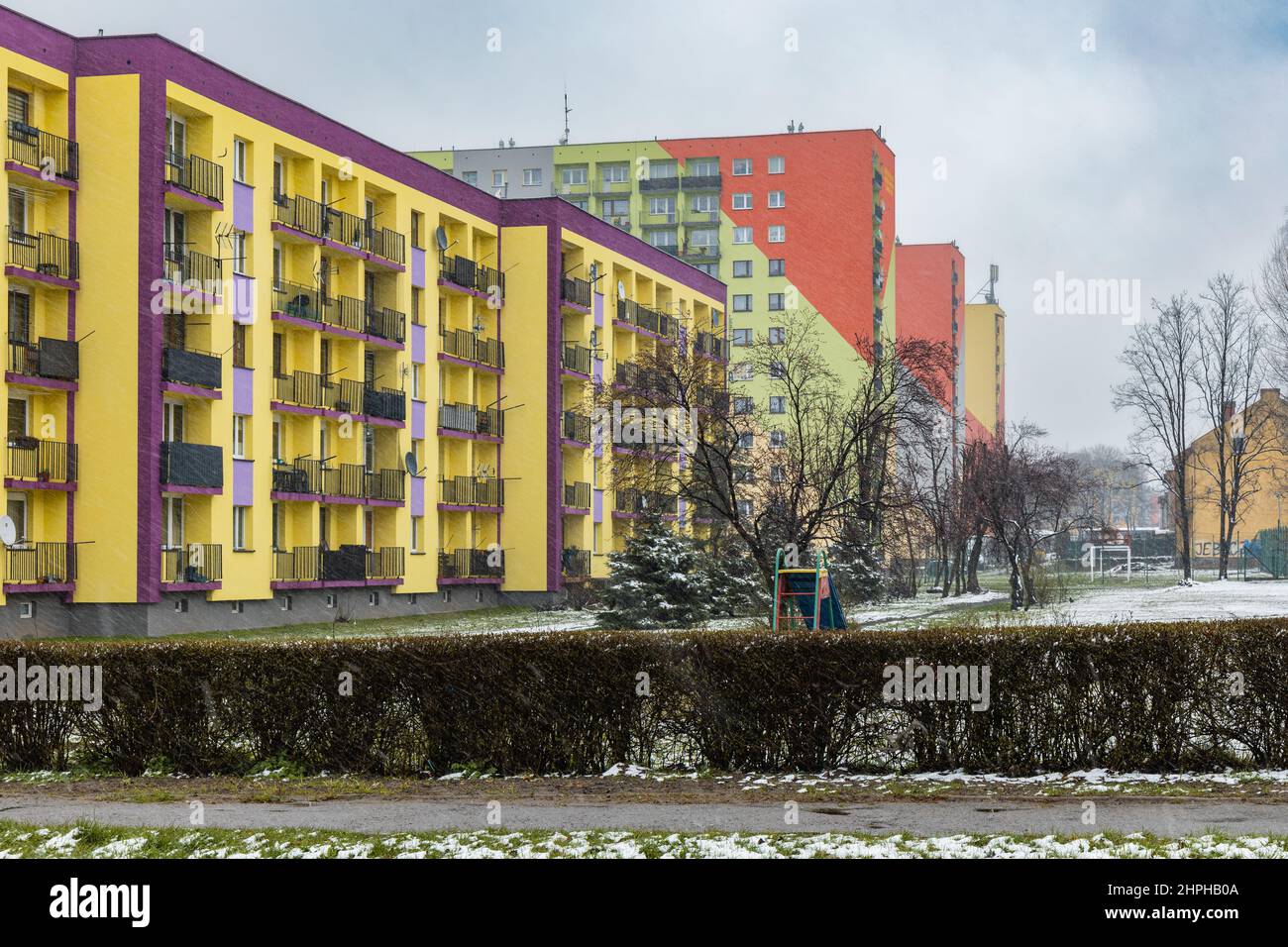 Zawiercie, Pologne - avril 2021 : façade colorée d'un bloc d'appartements le jour de la neige Banque D'Images