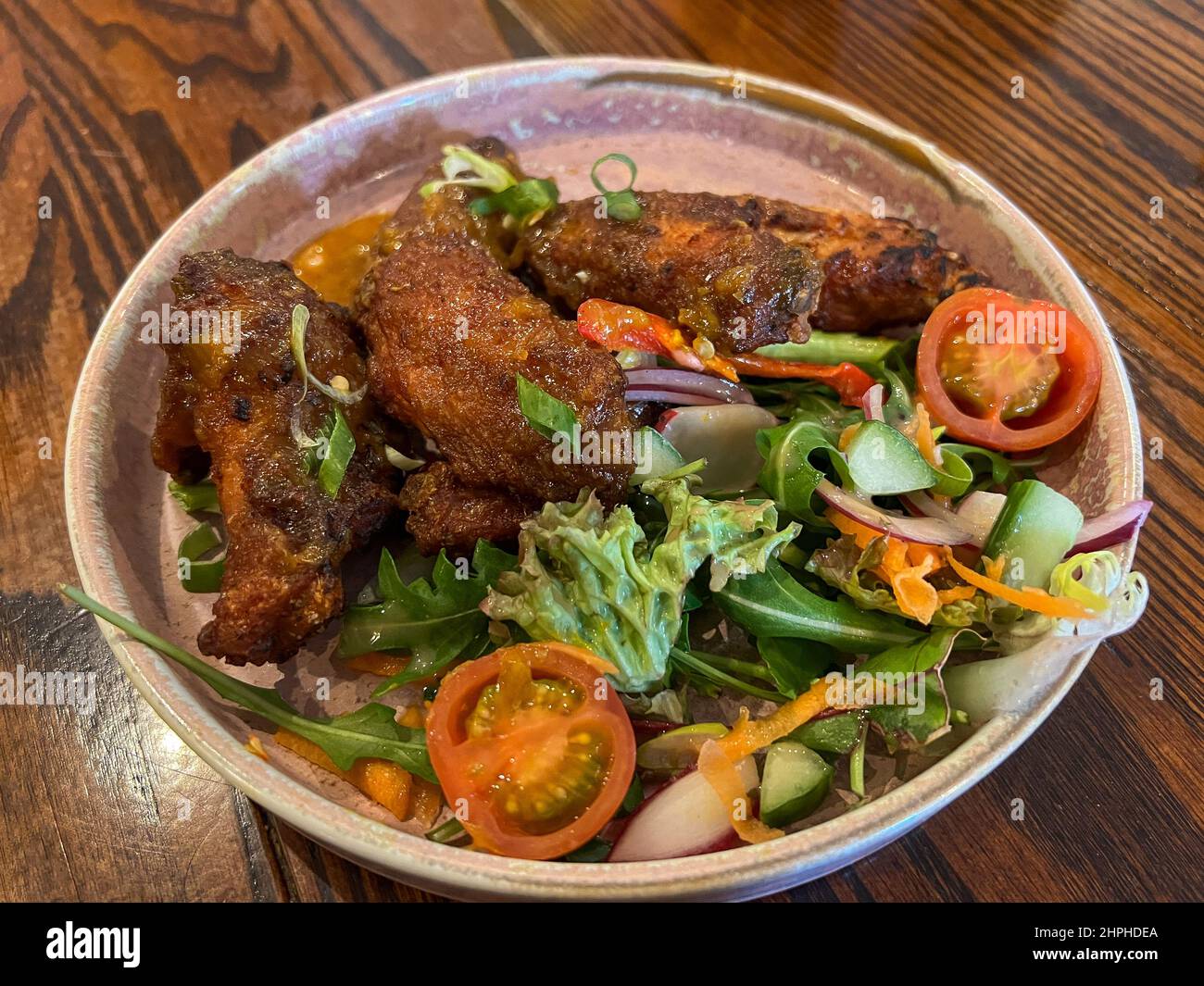 Griller des ailes de poulet avec un hors-d'œuvre à salade Banque D'Images