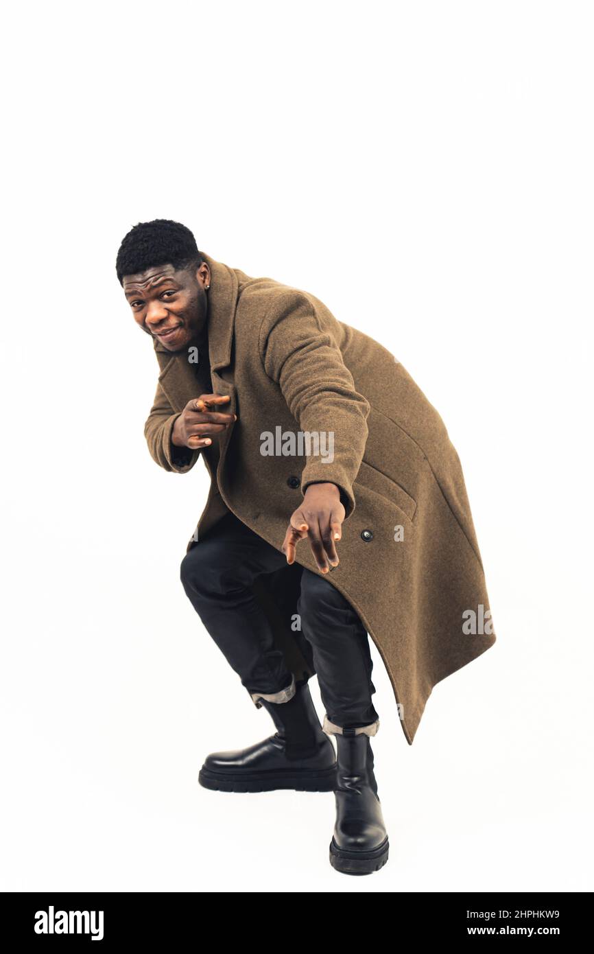 Afro-américain ayant la modelage amusant pointant sur l'arrière-plan blanc de la caméra - plein plan. Photo de haute qualité Banque D'Images