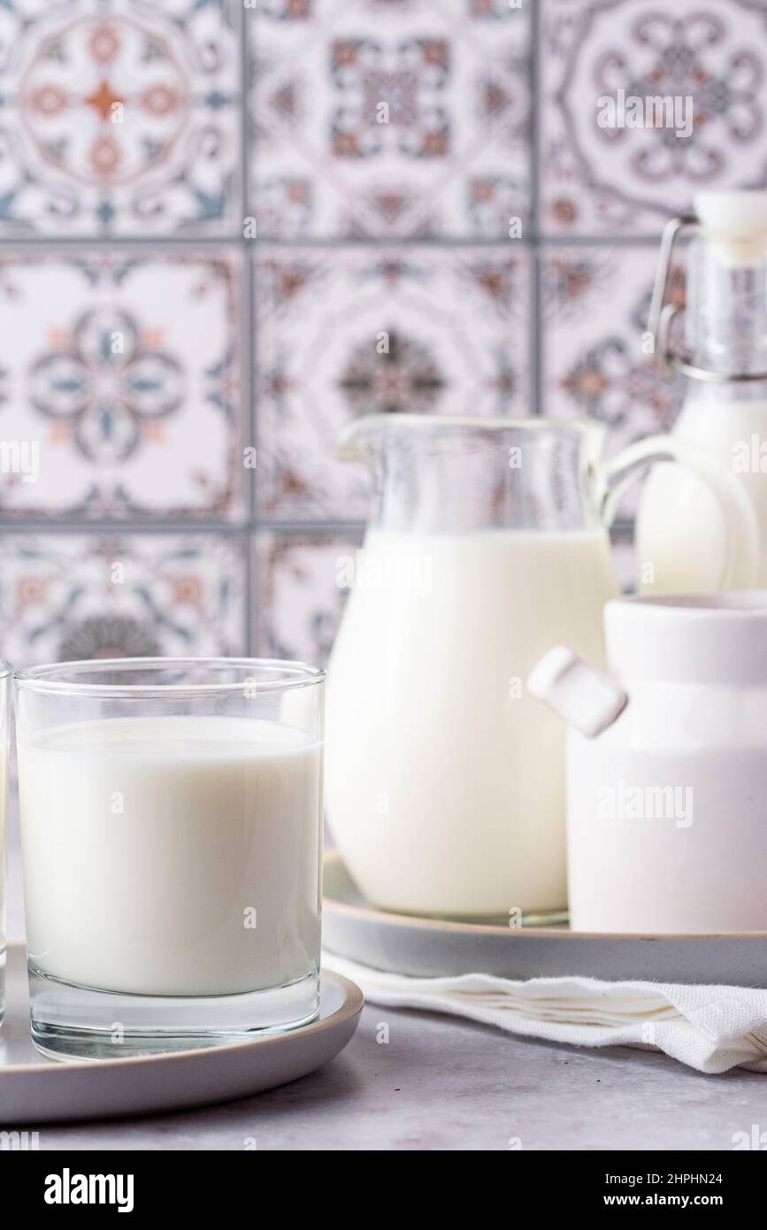 Du lait dans un verre, un carafe et un biberon sur fond clair Banque D'Images