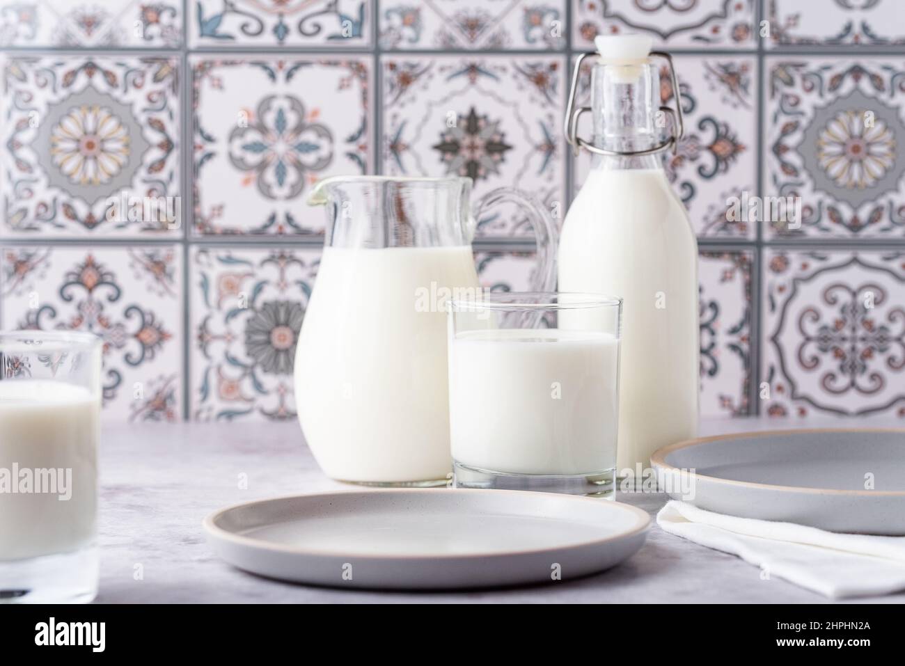 Du lait dans un verre, un carafe et un biberon sur fond clair Banque D'Images