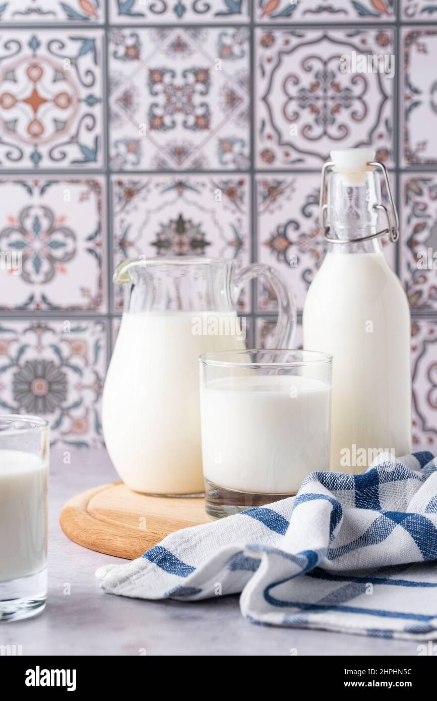 Du lait dans un verre, un carafe et un biberon sur fond clair Banque D'Images