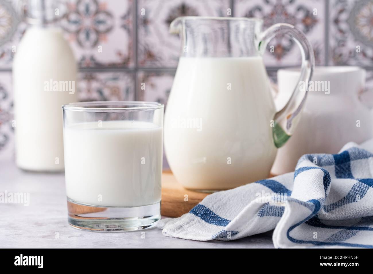 Du lait dans un verre, un carafe et un biberon sur fond clair Banque D'Images
