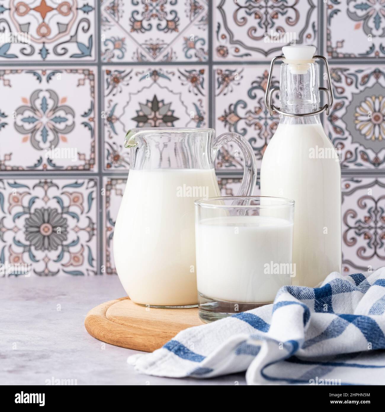 Du lait dans un verre, un carafe et un biberon sur fond clair Banque D'Images