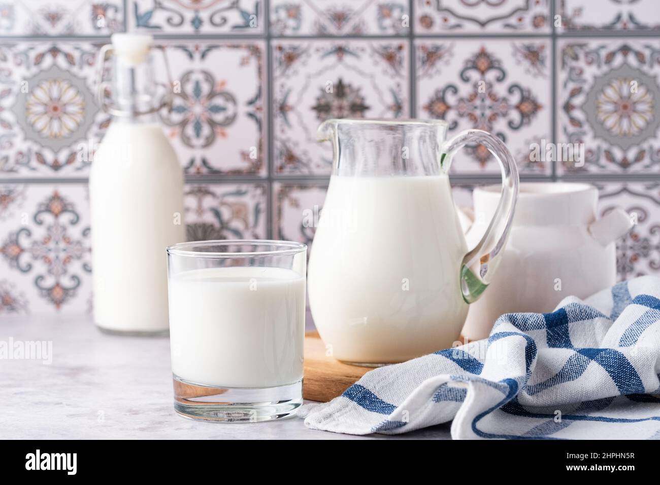 Du lait dans un verre, un carafe et un biberon sur fond clair Banque D'Images