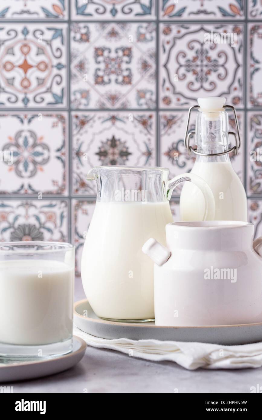 Du lait dans un verre, un carafe et un biberon sur fond clair Banque D'Images