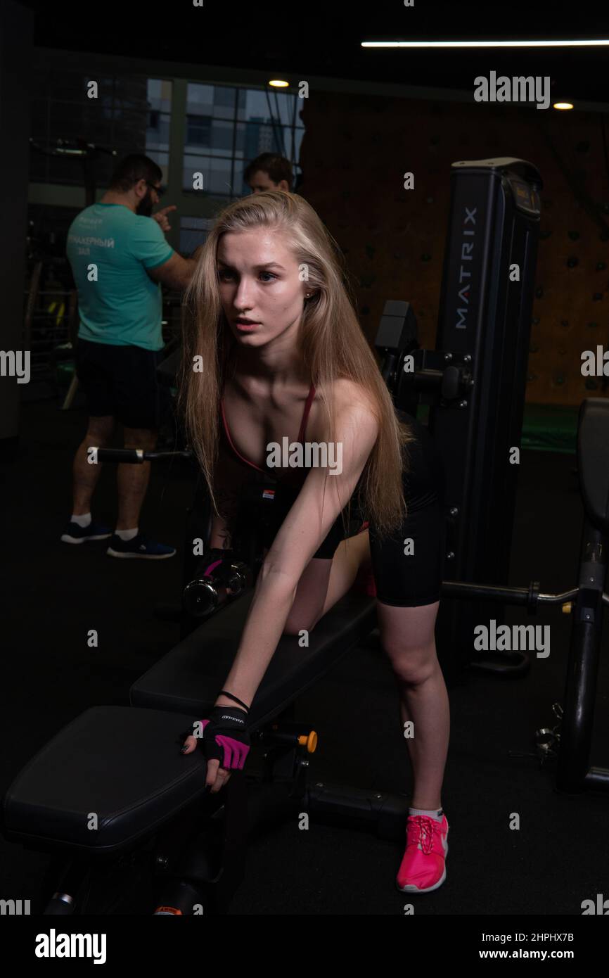 RUSSIE, MOSCOU - 11 FÉVRIER 2022: L'entraînement dirigé par un instructeur aide un beau client à effectuer des exercices dans un club de fitness, le concept de jouer du sport Banque D'Images