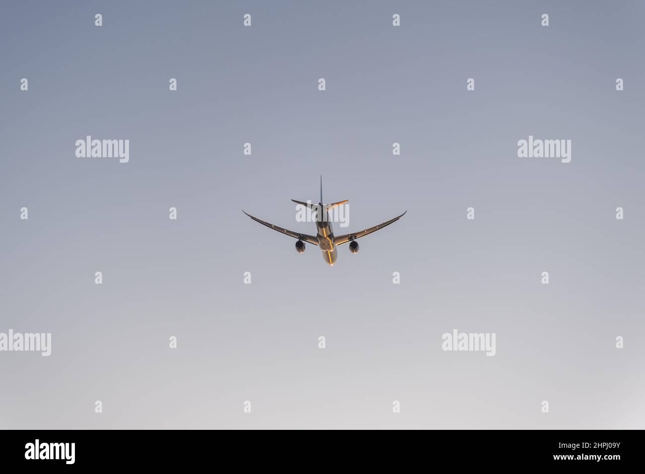 Silhouette d'un avion à deux moteurs dans le ciel au coucher du soleil Banque D'Images