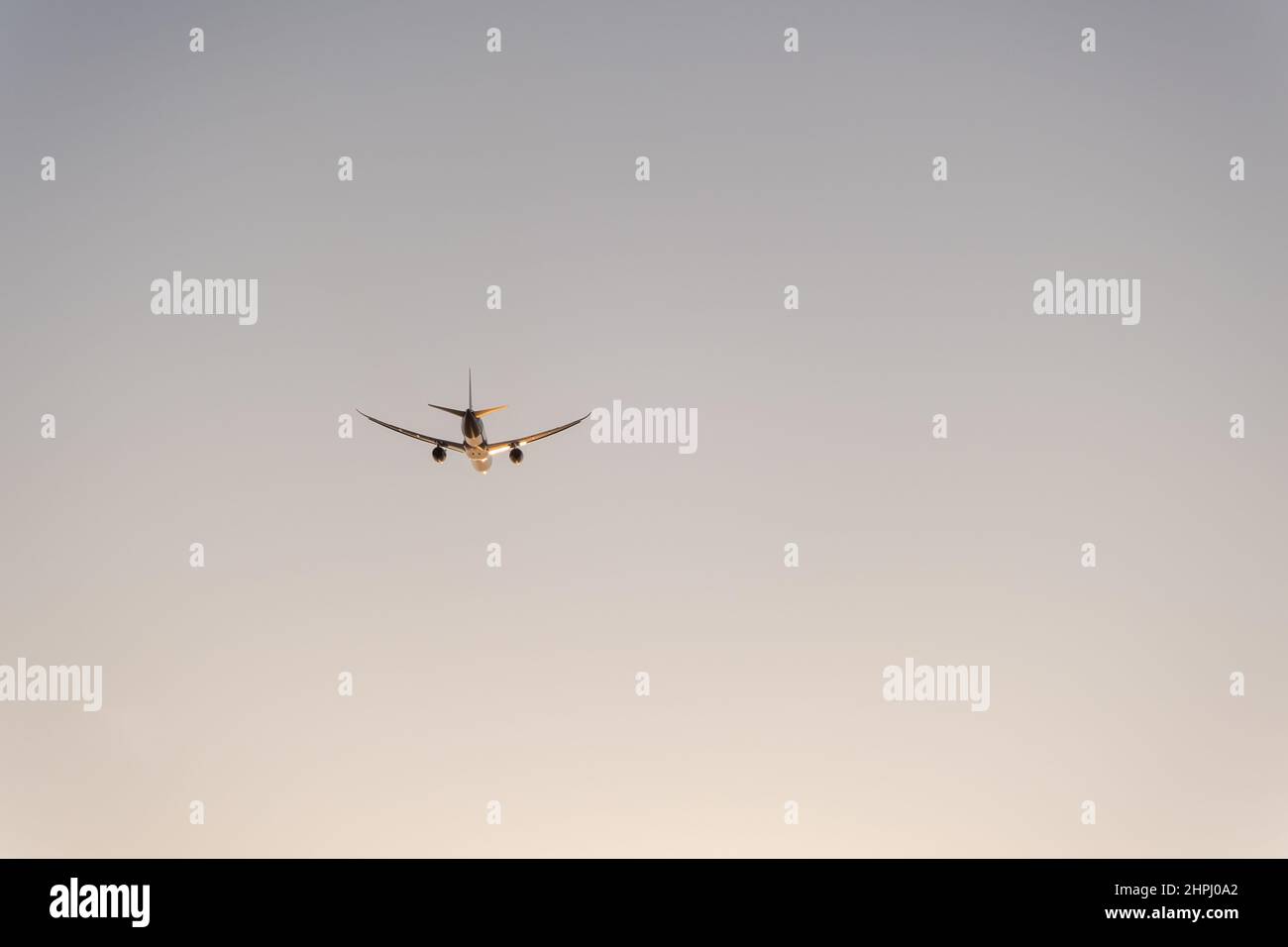 Silhouette d'un avion à deux moteurs dans le ciel au coucher du soleil Banque D'Images