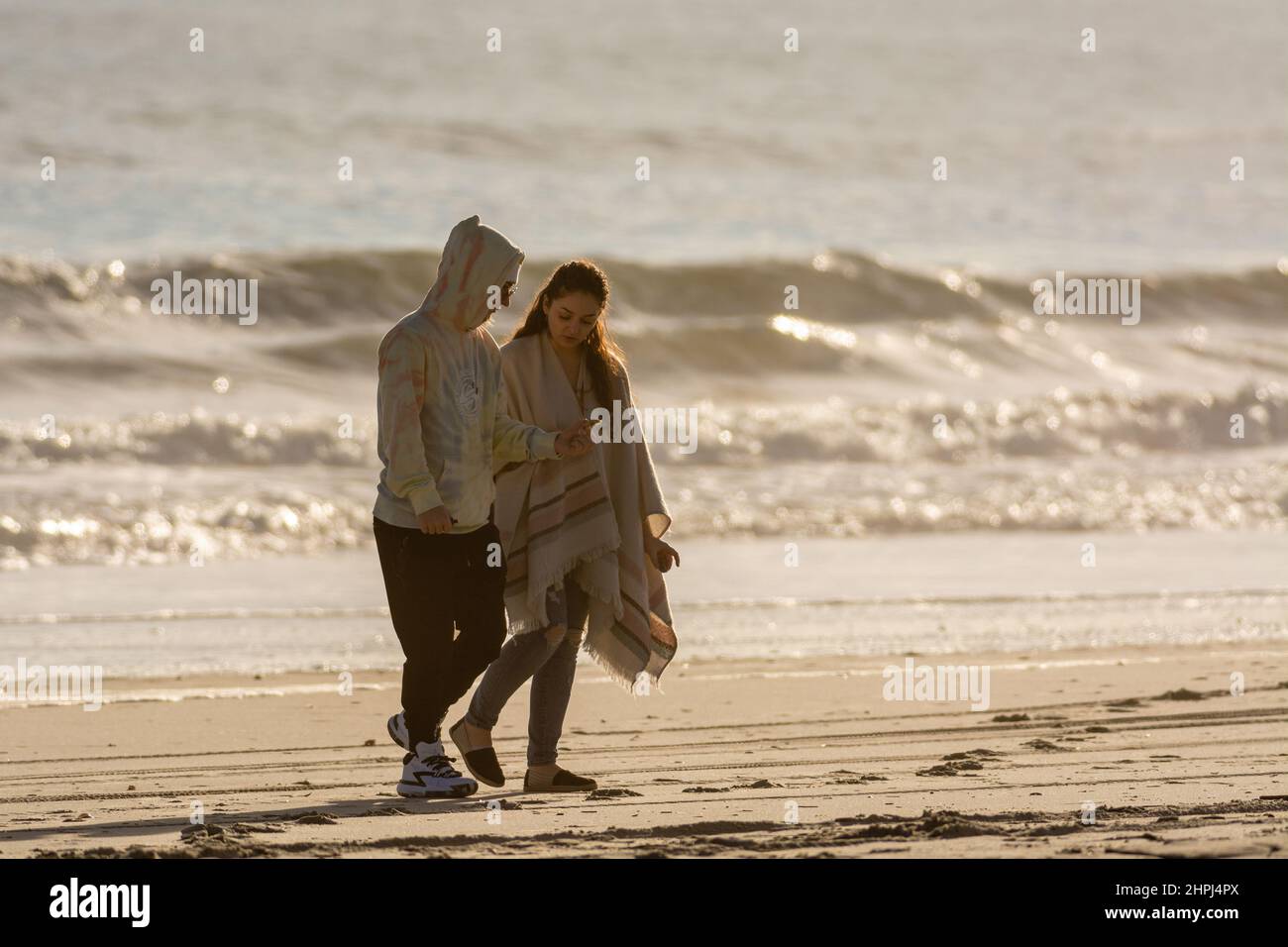 Vue magnifique sur un couple en marchant le long de la plage ensoleillée d'Emerald Isle, Caroline du Nord Banque D'Images Vue magnifique sur un couple en marchant le long de la plage ensoleillée d'Emerald Isle, Caroline du Nord Banque D'Images