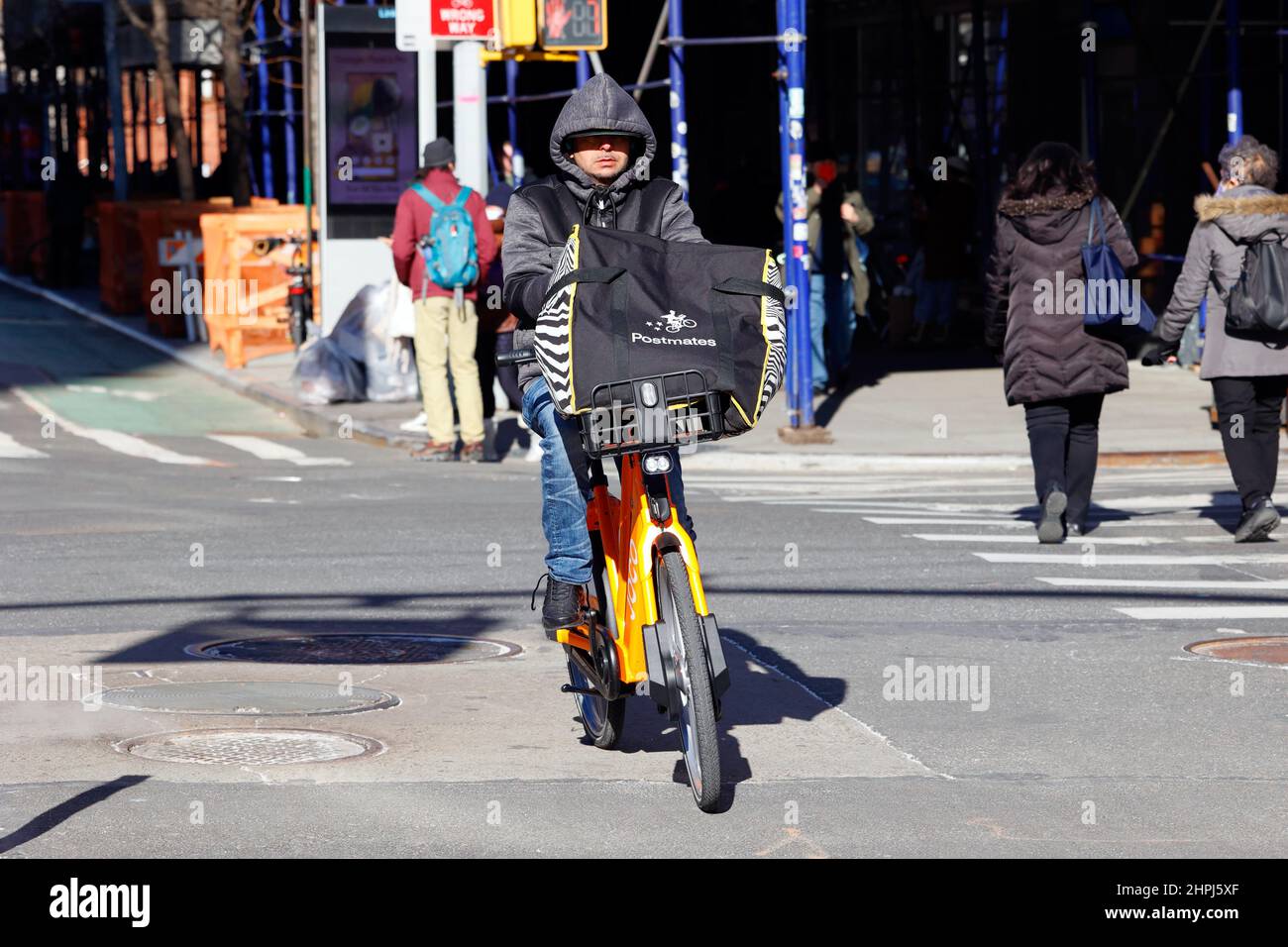 Une personne de livraison Postmates qui fait du vélo de location JOCO à New York, NY. Ce sont des besoins instantanés, un commerce rapide, une compagnie de livraison rapide Banque D'Images