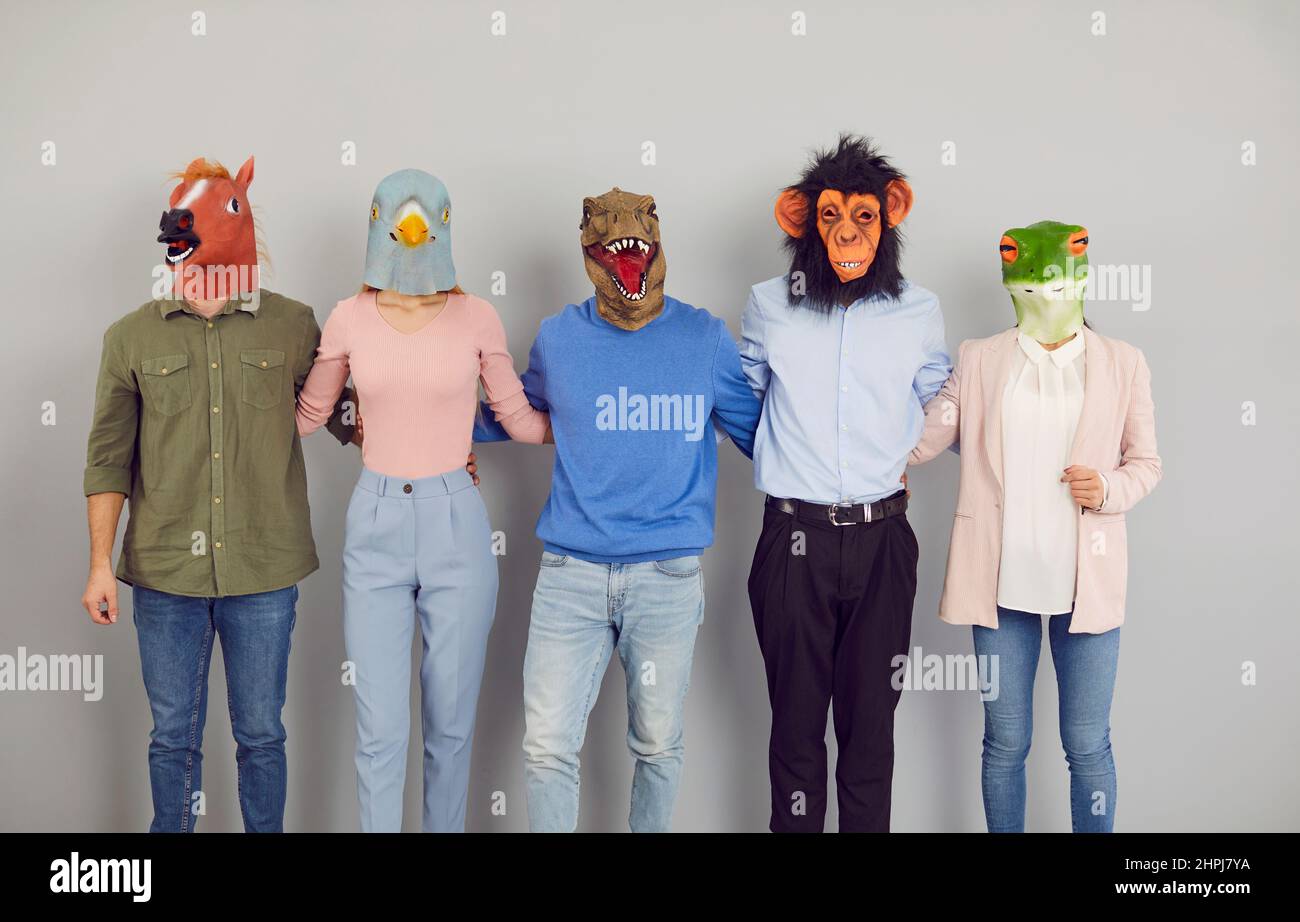 Équipe de jeunes dans des masques d'animaux amusants debout ensemble et se tenant les uns les autres Banque D'Images