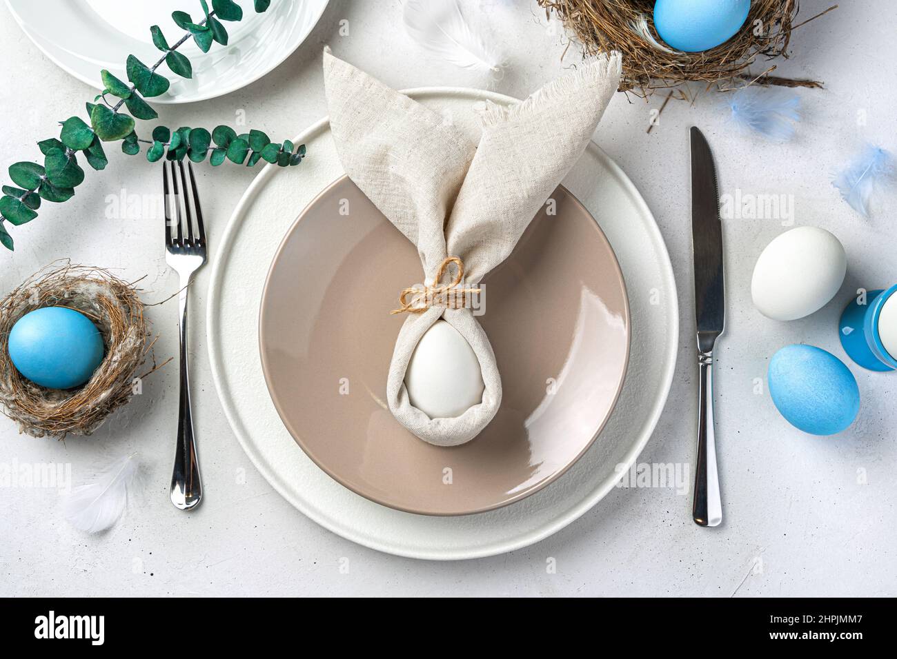 Joyeuses Pâques. Service festif de la table de Pâques avec un lapin de Pâques fait de serviettes et d'oeufs. Vue de dessus. Banque D'Images