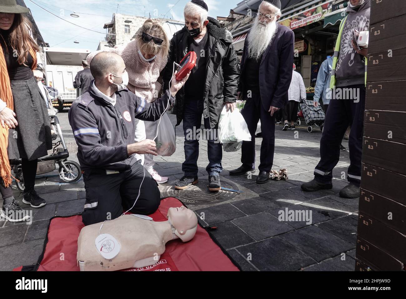 Jérusalem, Israël. 22nd févr. 2022. Les ambulanciers paramédicaux de Magen David Adom, le premier SGE d'Israël, démontrent et instruisent l'utilisation de la RCP et des défibrillateurs et leur importance pour sauver des vies le 22nd février, désigné Journée nationale de sensibilisation aux défibrillateurs, sur le marché de Shuk Mahane Yehuda. Des milliers de défibrillateurs sont installés et disponibles dans les lieux publics du pays. Crédit : NIR Amon/Alamy Live News Banque D'Images