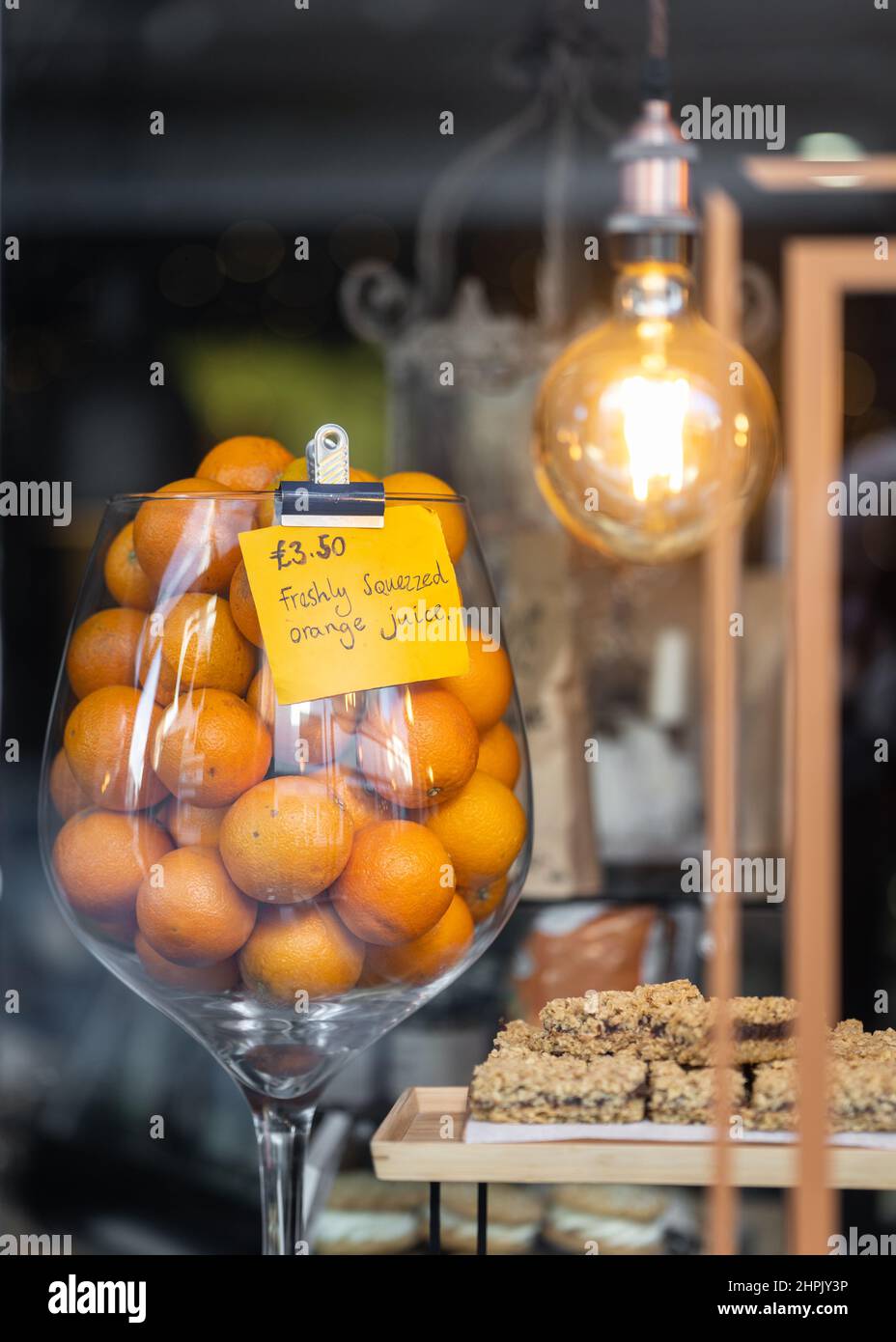 Jus d'orange fraîchement pressé dans la fenêtre du magasin annonçant une boisson de fruits savoureuse aux clients. Jus d'agrumes faits maison aux couleurs vives. Banque D'Images