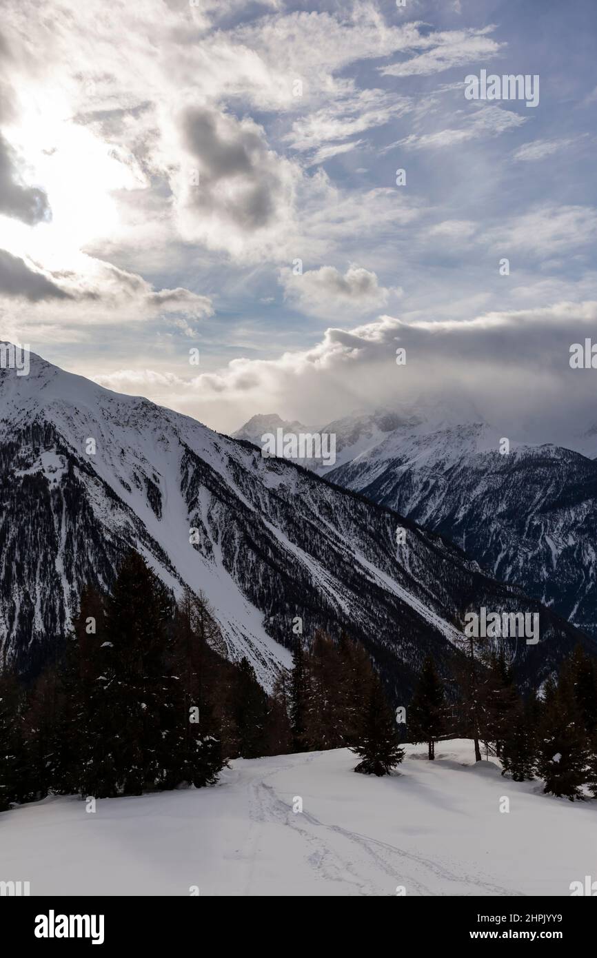 Paysage d'hiver dans les Alpes européennes, Graubuenden, Suisse, avec des montagnes enneigées, des nuages, et le ciel Banque D'Images