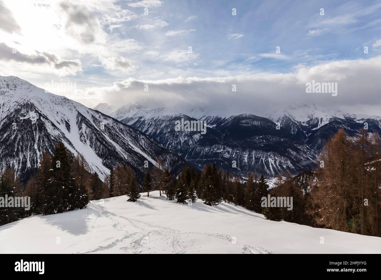 Paysage d'hiver dans les Alpes européennes, Graubuenden, Suisse, avec des montagnes enneigées, des nuages, et le ciel Banque D'Images
