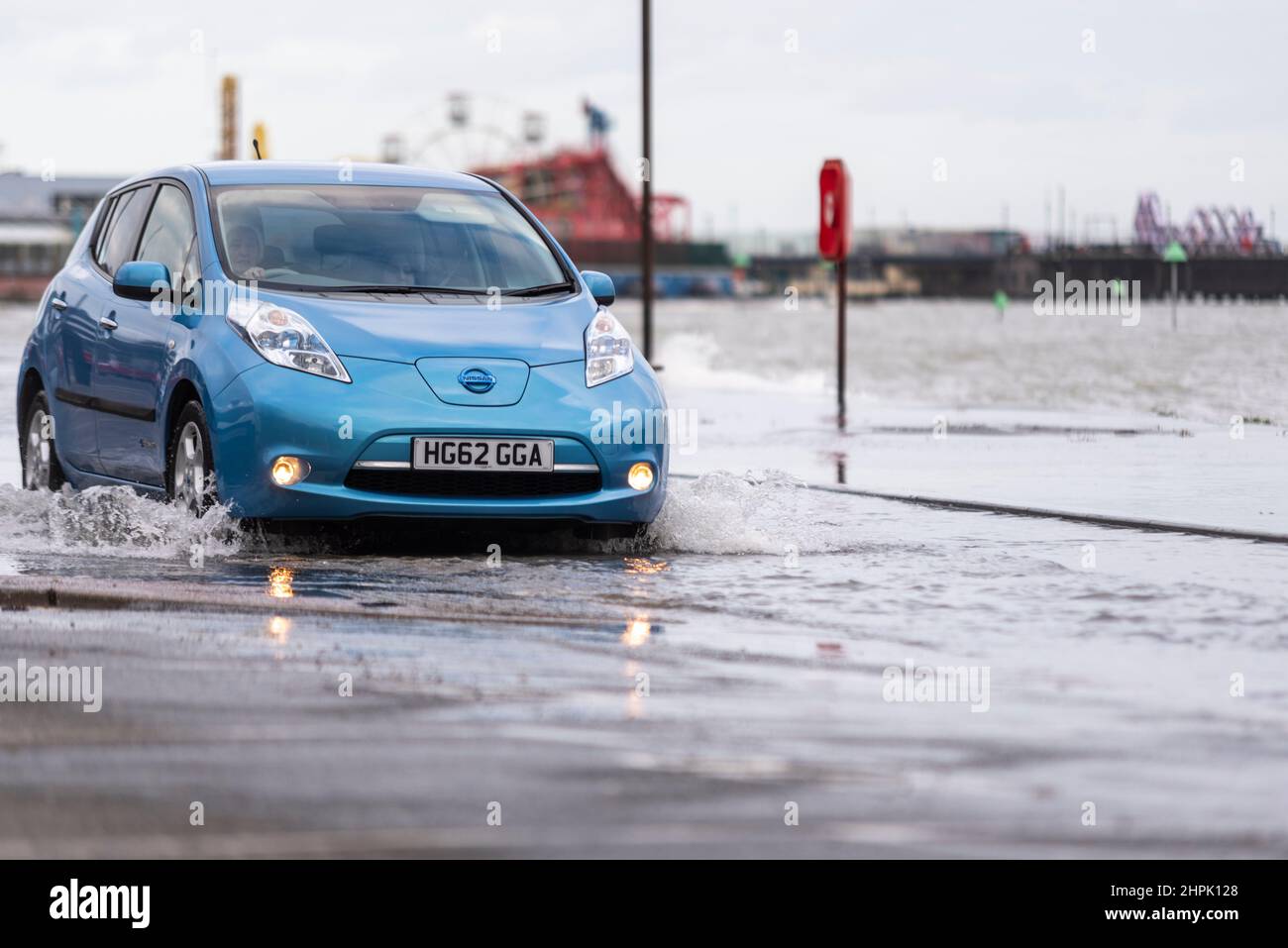 Nissan Leaf voiture électrique conduite dans les eaux d'inondation d'une marée haute combinée avec la tempête Franklin dans Southend on Sea, Essex, Royaume-Uni. Banque D'Images