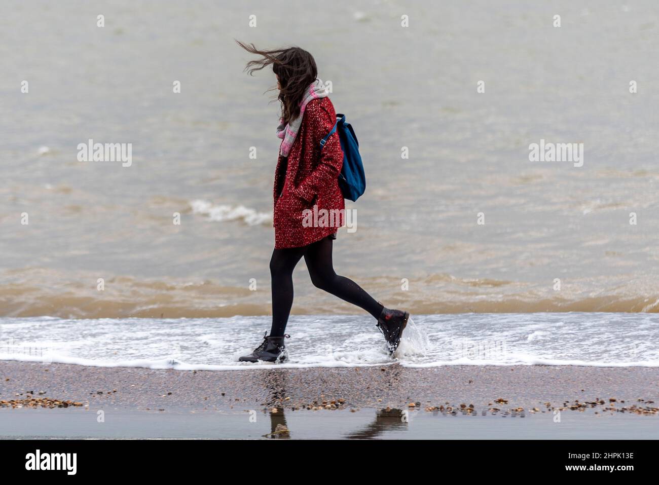 Une femelle se fait prendre par les inondations d'eau au-dessus de la voie lors d'une marée haute de montée combinée à Storm Franklin dans Southend on Sea, Essex, Royaume-Uni. Pieds mouillés Banque D'Images