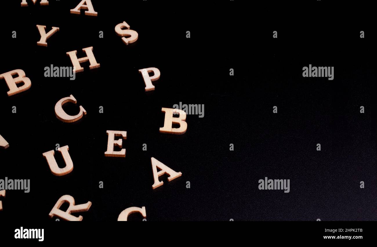 lettres en bois aléatoires isolées sur fond noir Banque D'Images