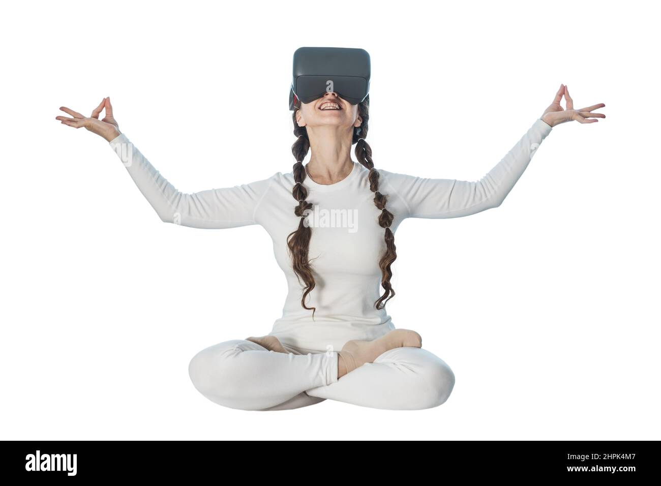 Une femme fait du yoga avec des lunettes de réalité virtuelle.Elle prend diverses poses de yoga et des sourires. Banque D'Images