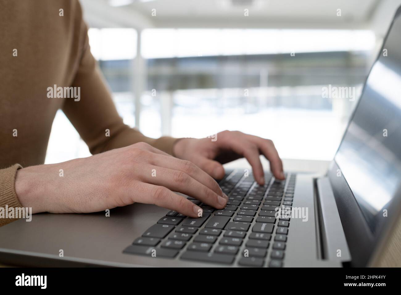 Mains du pdg ou de l'entrepreneur contemporain qui tape sur le clavier d'un ordinateur portable tout en étant assis sur le lieu de travail et en travaillant sur un nouveau projet ou en analysant des données Banque D'Images