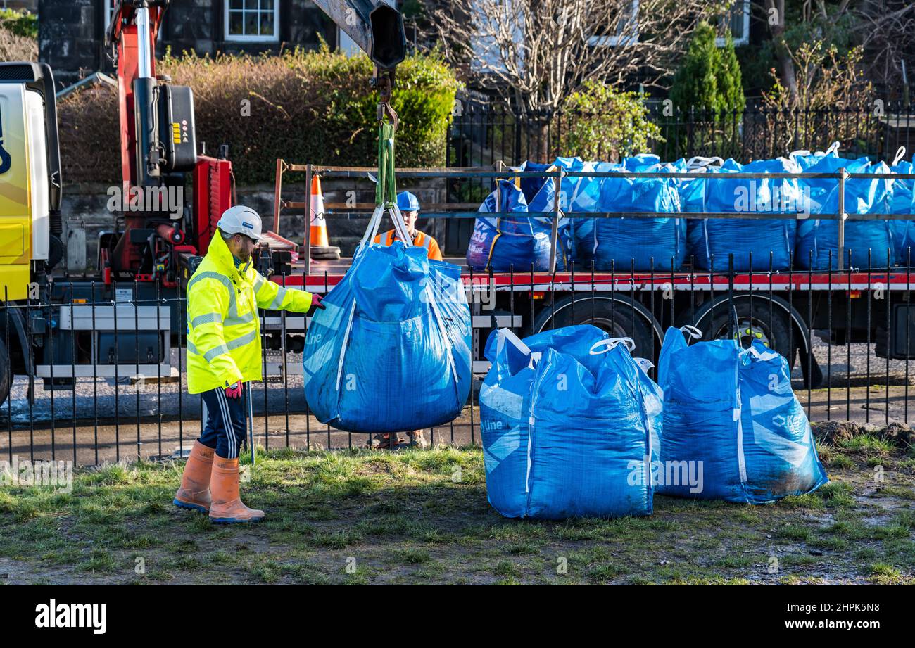 Trinity Primary School, Édimbourg, Écosse, Royaume-Uni, 22 février 2022. Terre végétale pour les écoles : excavation pendant le projet de biomes du jardin botanique royal, un surplus de terre végétale de 50 tonnes est accordé aux écoles, aux allotissements et aux organismes communautaires par la société de construction Balfour Beatty. Une livraison de 5 tonnes a lieu à l'école primaire Trinity pour transporter la terre ou la terre pour remplir les planteurs dans le jardin de l'école pour que les élèves cultivent des légumes. Les élèves du primaire 4 utilisent des récipients de toutes formes et tailles pour déplacer la terre pour remplir les planteurs ; un travail d'équipe est nécessaire Banque D'Images