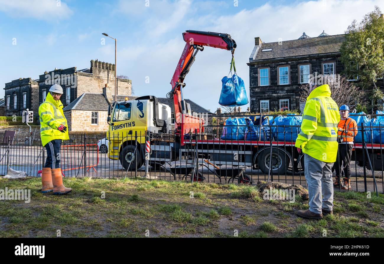 Trinity Primary School, Édimbourg, Écosse, Royaume-Uni, 22 février 2022. Terre végétale pour les écoles : excavation pendant le projet de biomes du jardin botanique royal, un surplus de terre végétale de 50 tonnes est accordé aux écoles, aux allotissements et aux organismes communautaires par la société de construction Balfour Beatty. Une livraison de 5 tonnes a lieu à l'école primaire Trinity pour transporter la terre ou la terre pour remplir les planteurs dans le jardin de l'école pour que les élèves cultivent des légumes. Les élèves du primaire 4 utilisent des récipients de toutes formes et tailles pour déplacer la terre pour remplir les planteurs ; un travail d'équipe est nécessaire Banque D'Images