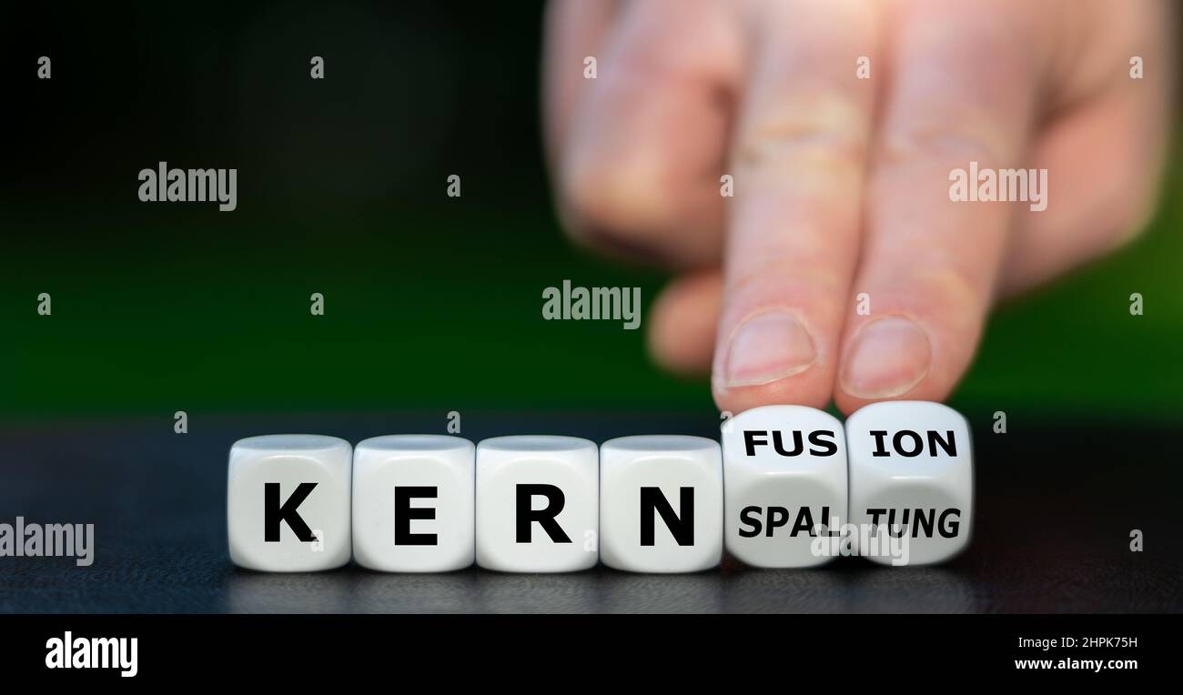 La main tourne les dés et change le mot allemand 'Kernspaltung' (fission nucléaire) en 'Kernfusion' (fusion nucléaire). Banque D'Images