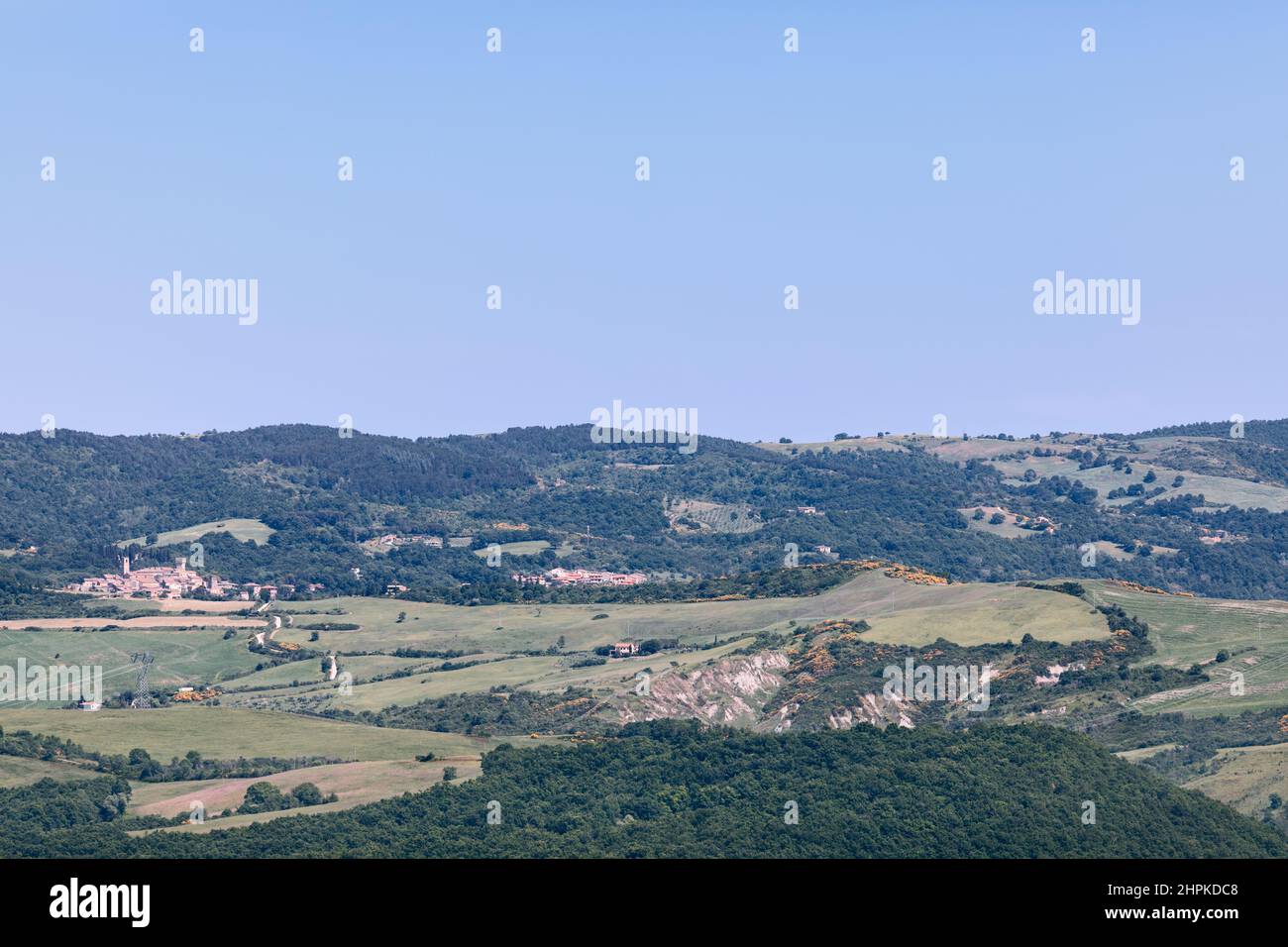 Collines ondoyantes de Toscane et une ville médiévale au loin. Été, Italie Banque D'Images