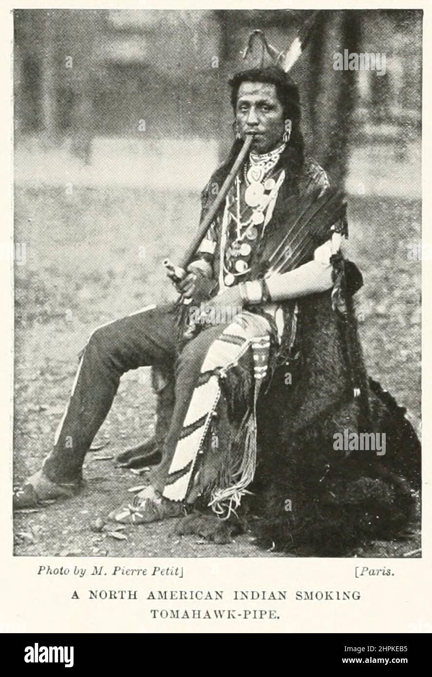 A North American Indian fumant Tomahawk-pipe du livre The Living races of Mankind; Volume 2 par Henry Neville Hutchinson, publié à Londres en 1901 par Hutchinson & co Banque D'Images