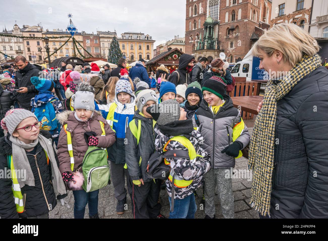 De jeunes écoliers et un professeur viennent regarder les scènes de la nativité de Cracovie Szopka exposées lors du concours annuel de décembre, sur la place du marché principal, à Cracovie, en Pologne Banque D'Images