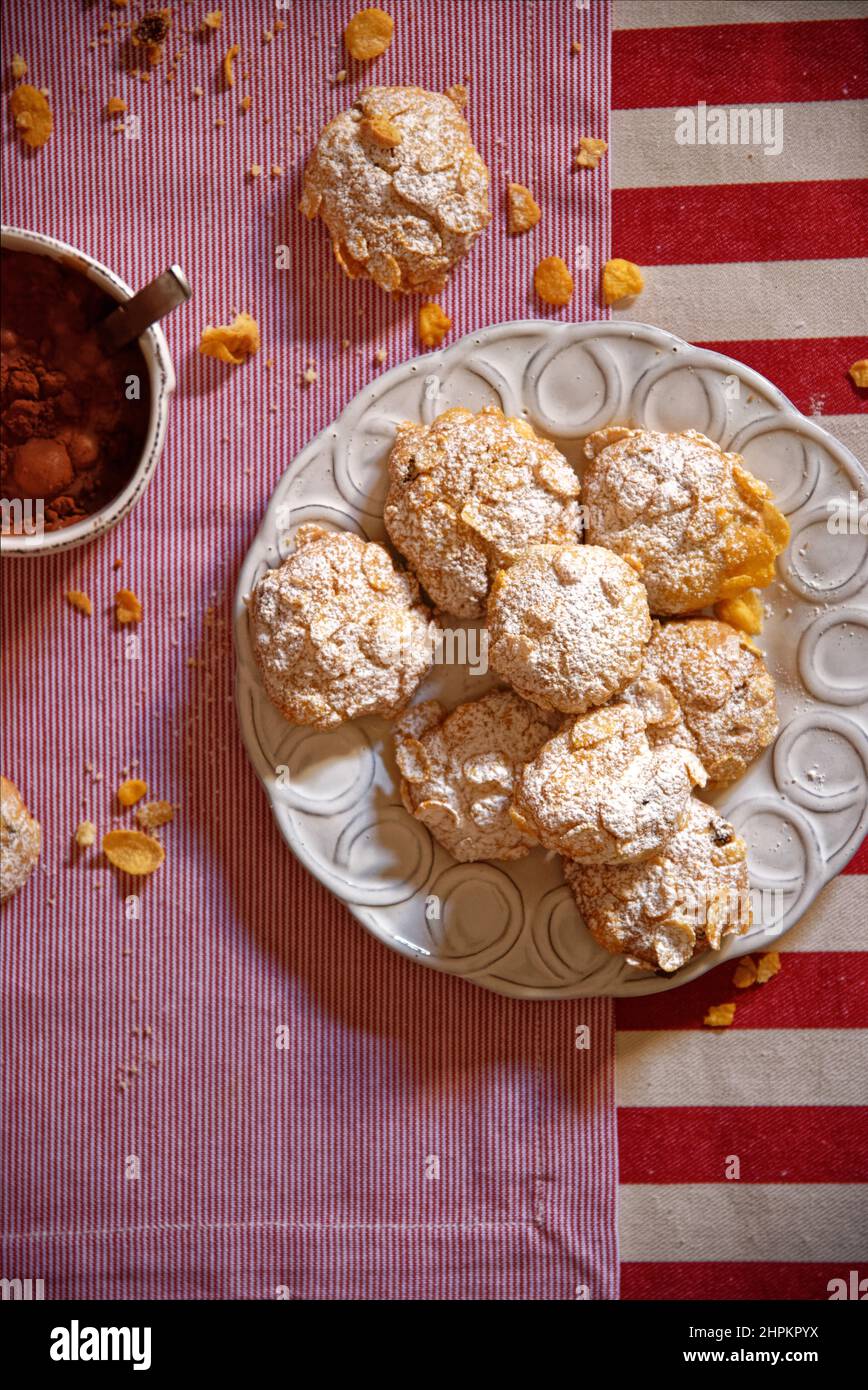 Biscuits faits maison aux céréales avec sucre glace dans une assiette de céramique blanche et une tasse de chocolat avec cacao glace dans des sets rouges et blancs rayés Banque D'Images