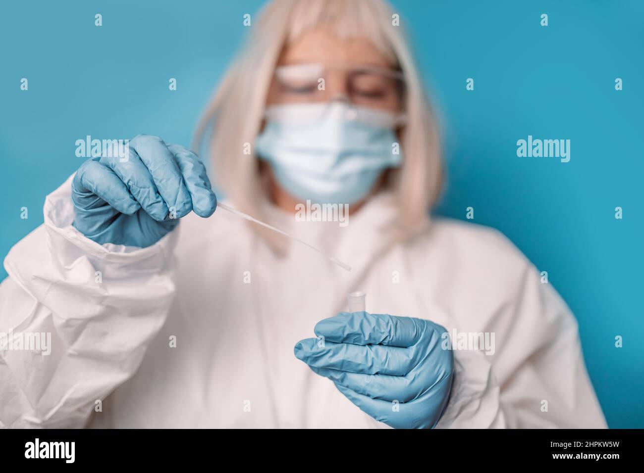 Test pcr Covid 19. Médecin en costume de protection masque médical gants utilisant un échantillon de salive Swab pour le diagnostic du virus coronavirus 19 covid en laboratoire. Banque D'Images