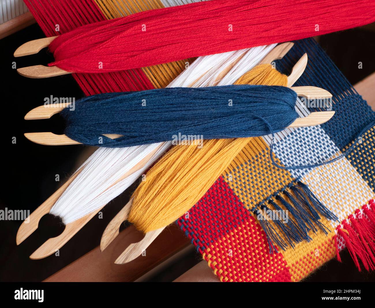 Quatre navettes avec fils de couleur vive pour créer une tapisserie. Tissage de fils de quatre couleurs, gros plan Banque D'Images