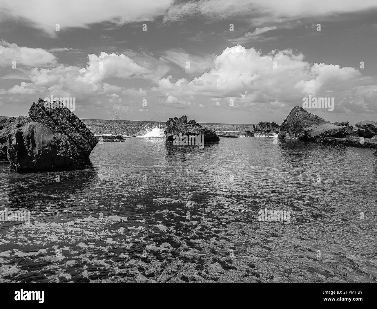 Photo monochrome des Boulders dans la mer à Forresters Beach sur la côte centrale, Nouvelle-Galles du Sud, Australie Banque D'Images