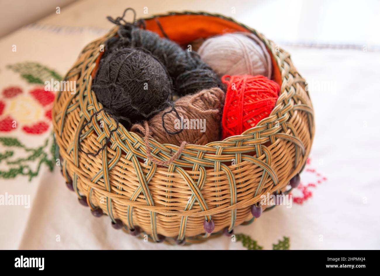 Panier en osier sur une table avec boules de laine Banque D'Images