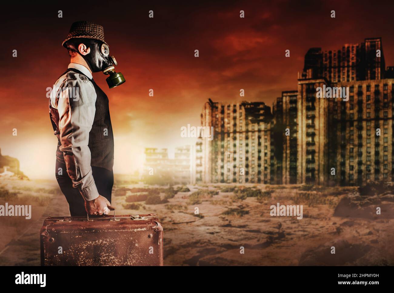 Photo d'un homme post-apocalyptique dans une tenue, un chapeau, un masque à  gaz et une valise habillée sur le désert de la guerre nucléaire de la ville  détruite Photo Stock - Alamy