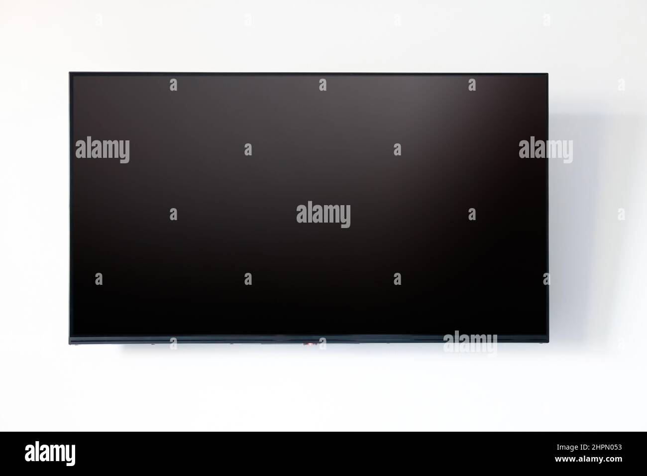 Écran LED vierge du téléviseur sur fond de mur blanc. Vue avant de l'écran de télévision vide noir, espace de copie, modèle de maquette Banque D'Images