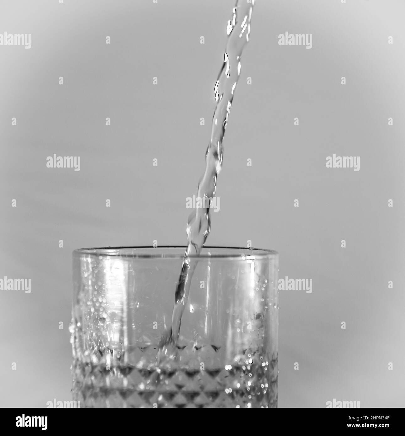 Verre à l'eau claire courante et fond gris foncé Banque D'Images