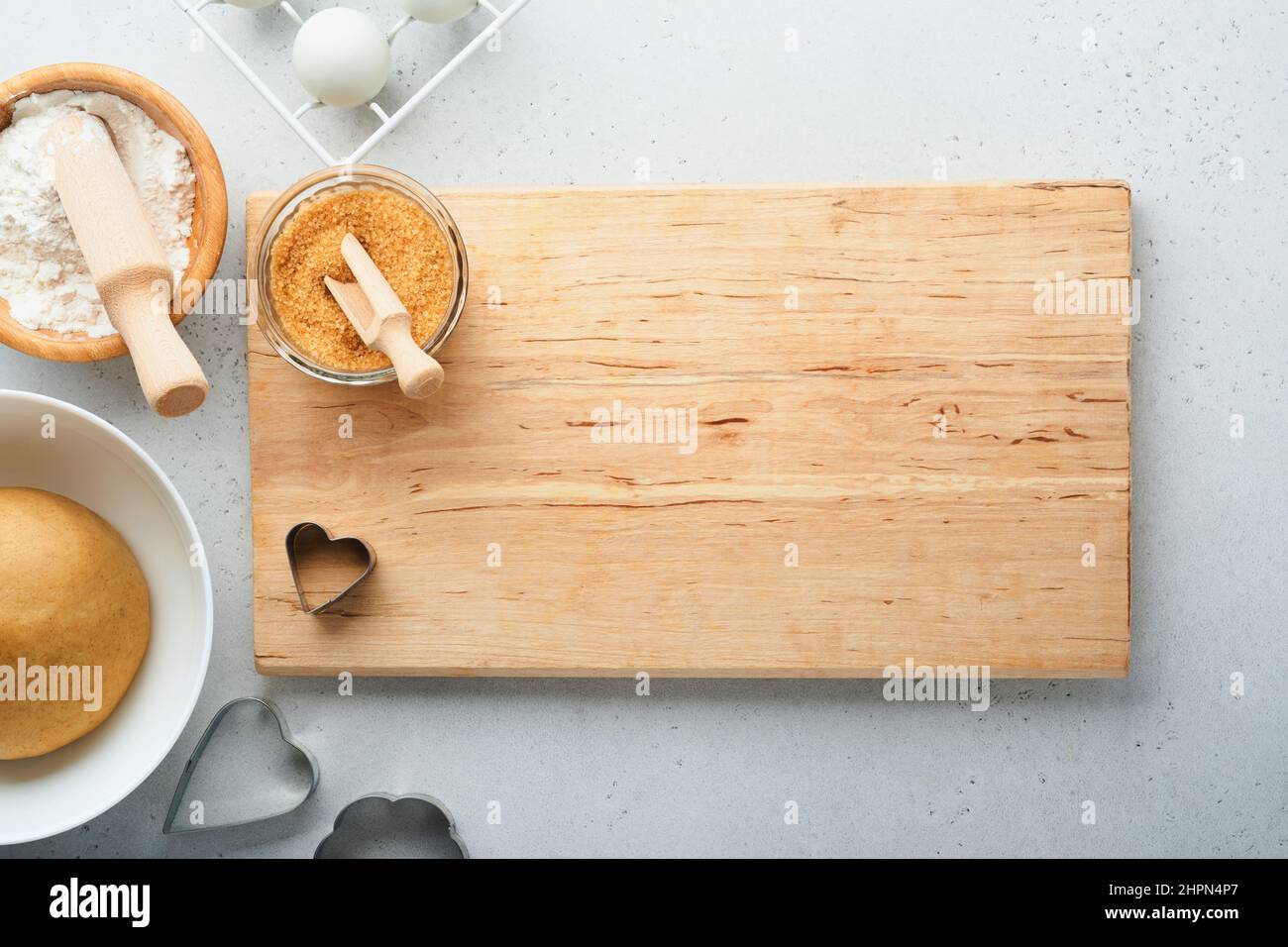 Ingrédients de boulangerie et ustensiles de cuisine sur fond blanc vue du dessus. Préparation des biscuits de sucre de coeur. Fond de cuisson. Farine, oeufs, sucre, épices Banque D'Images