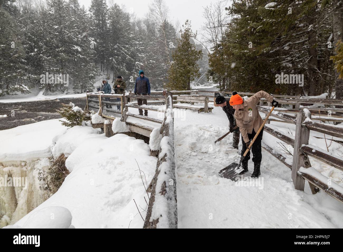 Paradise, Michigan - les employés du ministère des Ressources naturelles du Michigan déneigement de la plate-forme d'observation des chutes de Tahquamenon. Le froz Banque D'Images