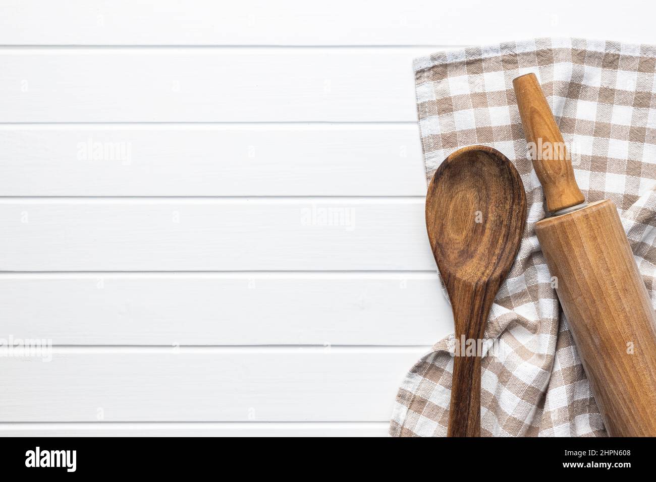 Broche roulante et cuillère en bois sur une table en bois avec une nappe à carreaux. Vue de dessus avec espace de copie. Banque D'Images