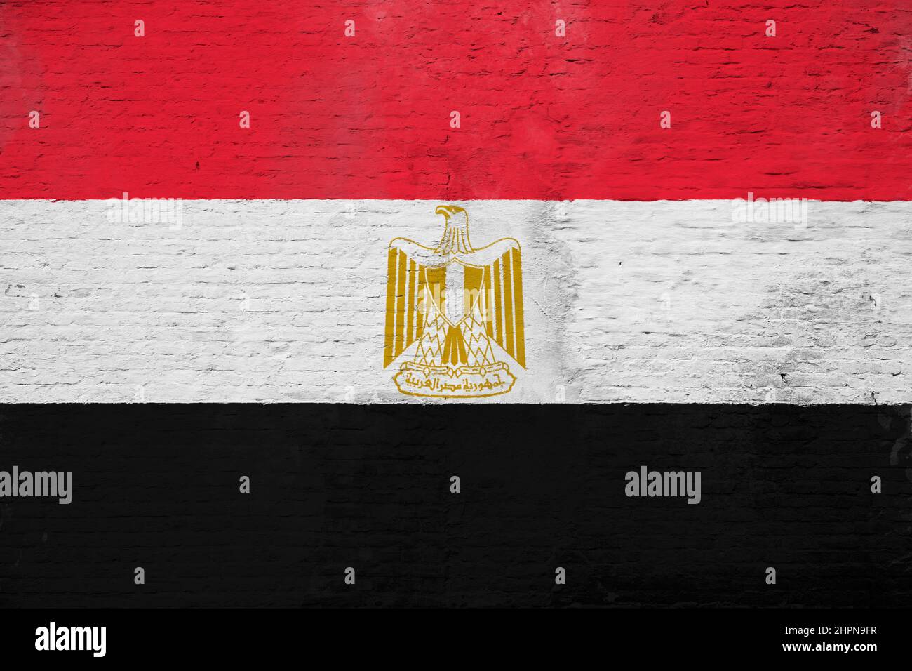 Photo plein cadre d'un drapeau de l'Égypte recouvert d'intempéries peint sur un mur en brique plâtrée. Banque D'Images