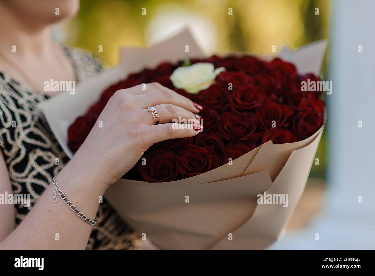 Bouquet de roses rouges, bague d'or pour femmes avec une pierre. Bouquet de fleurs rouges. Une offre de mariage Banque D'Images