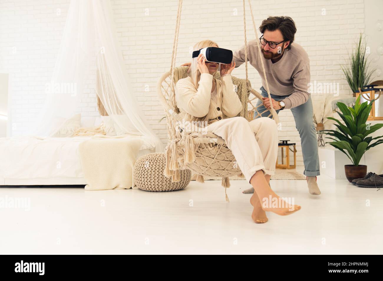 Blonde de race blanche d'âge moyen fasciné par la technologie VR que son mari barbu lui a montré. Photo de haute qualité Banque D'Images