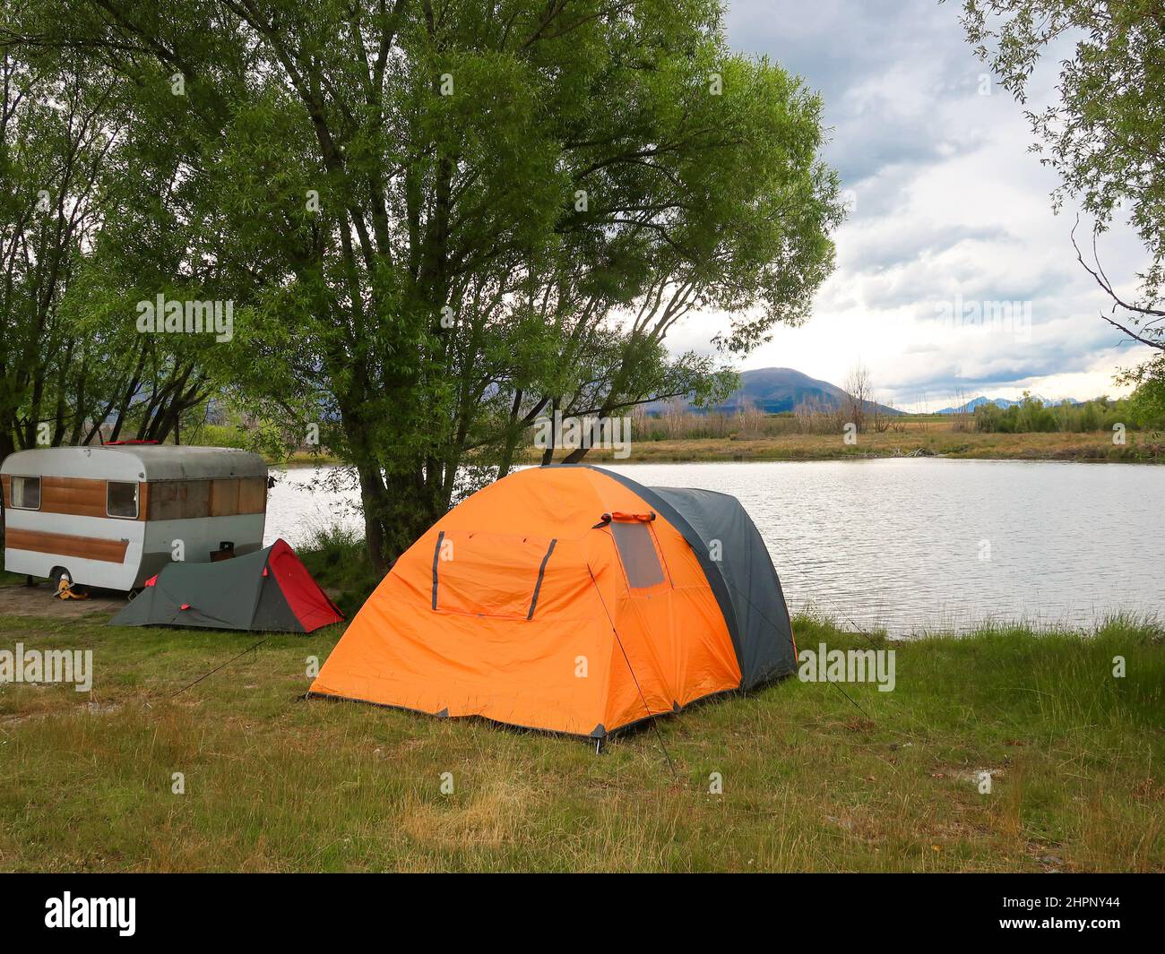 Liberté campeurs vacances avec une tente et caravane sur le bord du lac Poaka, île du Sud, Nouvelle-Zélande Banque D'Images