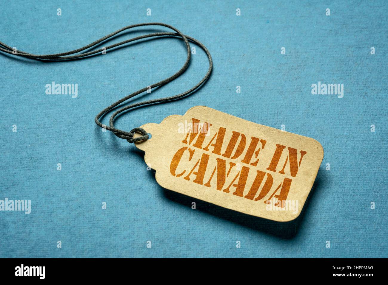 Panneau fabriqué au Canada - pochoir rouge sur une étiquette de prix en papier contre le bois de grunge Banque D'Images