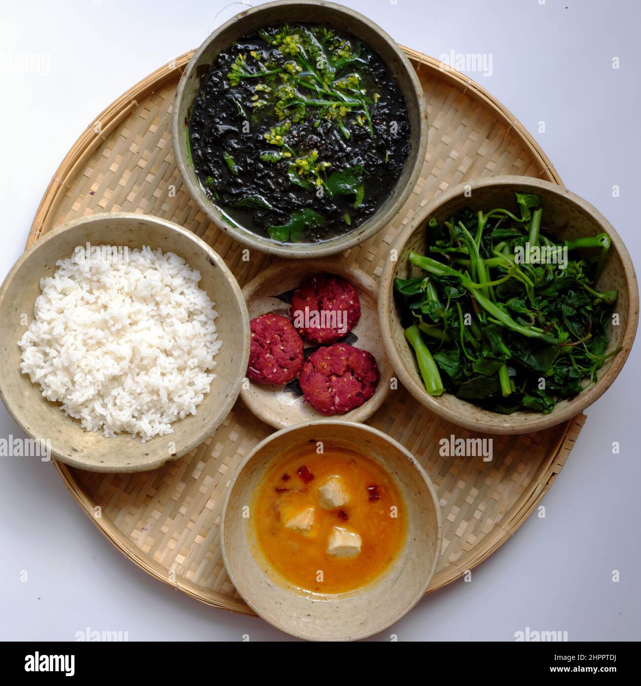Vue de dessus cuisine vietnamienne pour un repas de famille quotidien, plateau de repas végétalien avec soupe d'algues végétales, épinards bouillis avec tofu, menu sans viande bon pour Banque D'Images
