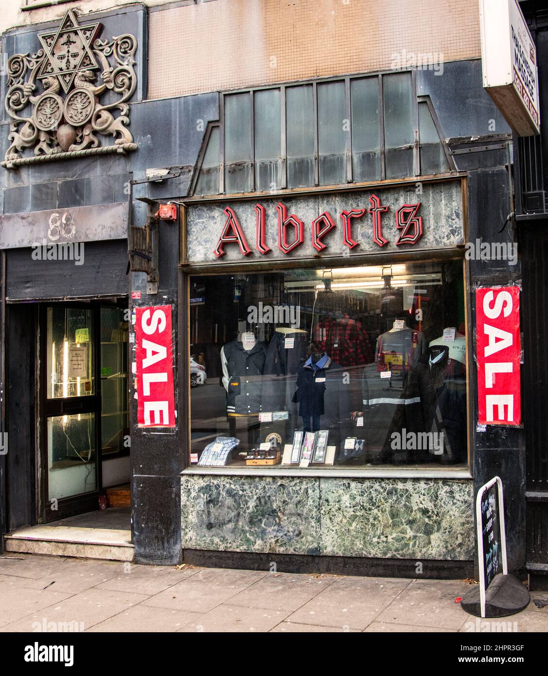 Alberts boutique de vêtements pour hommes en 88 Whitechapel High St, Londres; bâtiment classé Grade II avec étoile de David, Lions de Juda et Menorah à l'entrée Banque D'Images